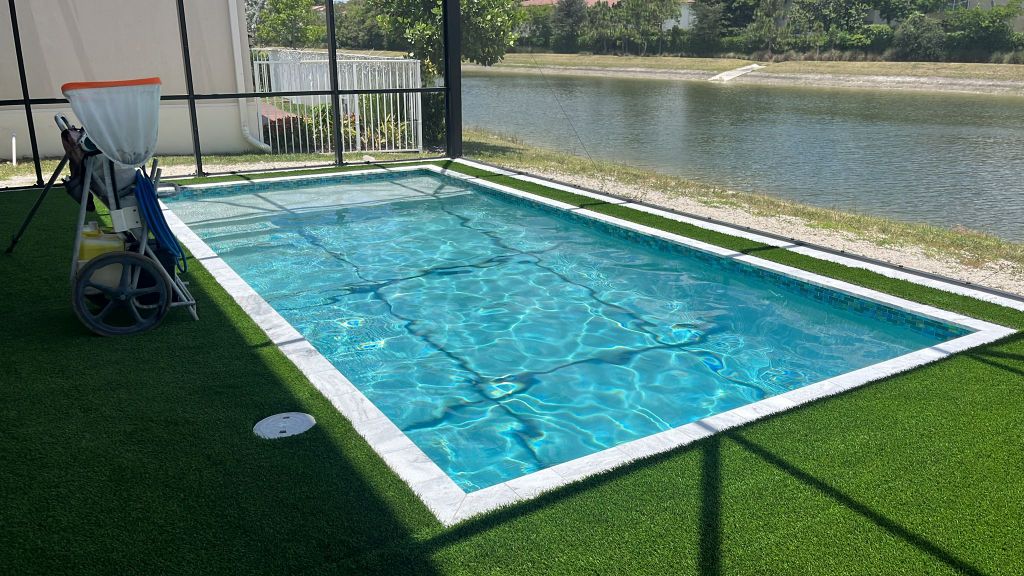 Rectangular pool with screen enclosure and lakeside view
