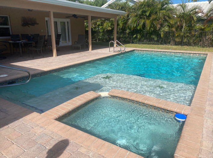 Beautiful pool with integrated spa and tropical palm landscaping